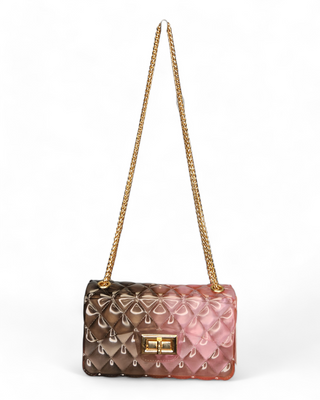 An elegant quilted jelly crossbody bag in an ombre design of pink and brown shades with a gold chain strap and clasp.