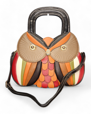 An owl-shaped handbag made of multi-colored faux leather with a jeweled owl clasp and black handles.
