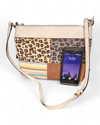 A patchwork crossbody bag with various animal prints, woven textures, and colorful stripes on the front, and a cow print on the back, featuring a beige top section and an adjustable strap.