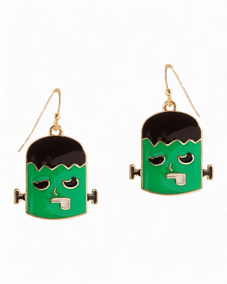 Frankenstein-themed enamel earrings. Each earring features a stylized depiction of Frankenstein's monster with a vivid green face, black hair