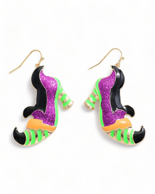A pair of witch shoe earrings with glittery purple, green, and black accents, featuring intricate detailing and whimsical design.