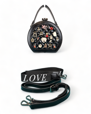 Black  crossbody handbag with a quilted face and adorned with charms and straps.
