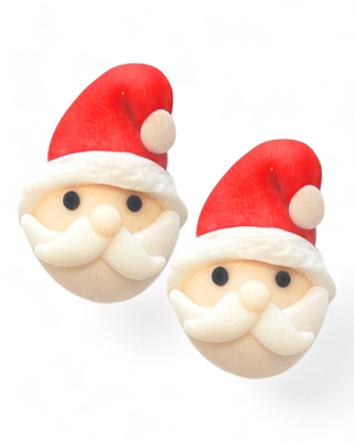 A pair of clay stud earrings featuring Santa Claus with red hats, white beards, and black eyes. The earrings have a whimsical and festive design, perfect for holiday w