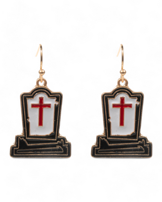 A pair of dangle earrings shaped like gravestones, featuring a black outline, white enamel filling, and a central red cross,