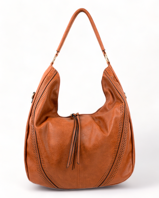 A caramel-colored vegan leather hobo bag with perforated details and a tassel, featuring a single shoulder strap and a relaxed silhouette.