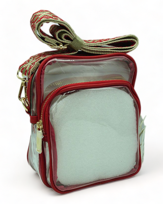 Clear shoulder bag with guitar strap and red trim.