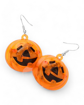 Transparent orange light-up pumpkin earrings featuring a carved jack-o'-lantern face. These earrings illuminate