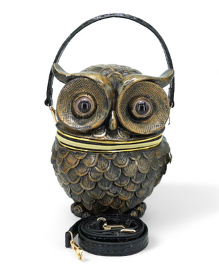 A gold owl-shaped handbag with intricate feather detailing and large eyes, including a detachable shoulder strap