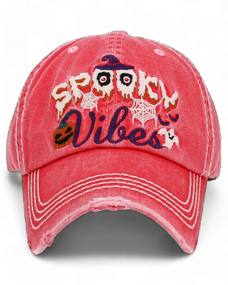 distressed baseball cap with embroidered text 'Spooky Vibes' featuring haunted eyes, spider webs, a pumpkin, and a ghost