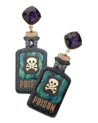 A pair of earrings featuring resin poison bottle pendants with a skull and crossbones design, topped with large purple gemstones