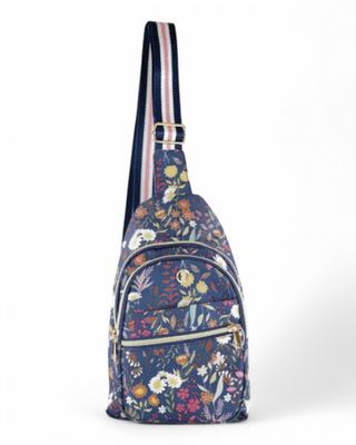 A floral-patterned sling bag with an adjustable striped strap, featuring multiple zippered compartments for storage.