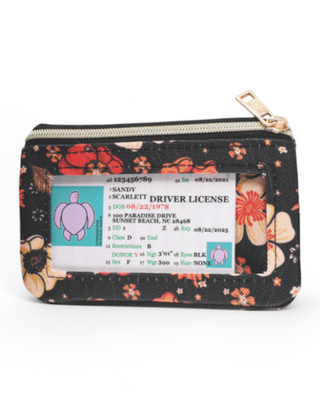 A compact zippered wallet with a transparent ID window and a printed floral design. The front features an ID slot, while the back has a gold pineapple emblem and an elastic slot for cards. The zipper is accented with a gold-tone pull tab.