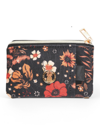 A compact zippered wallet with a transparent ID window and a printed floral design. The front features an ID slot, while the back has a gold pineapple emblem and an elastic slot for cards. The zipper is accented with a gold-tone pull tab.