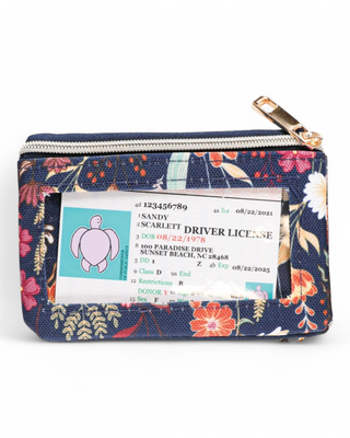 A compact floral-patterned wallet with a clear ID slot, zippered closure, and key ring attachment, designed for everyday convenience and style.