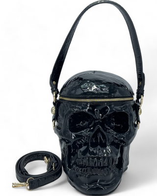 Skull-shaped crossbody handbag with a textured black finish, featuring a zippered top and detachable strap