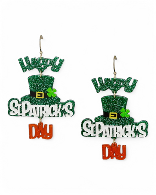 A pair of glittery St. Patrick’s Day earrings featuring green top hats, shamrocks, and "Happy St. Patrick’s Day" text with a dangling "Day" accent.