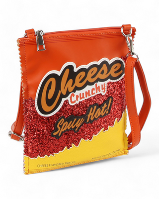 A crossbody bag designed to look like a snack package with "Cheese Crunchy Spicy Hot!" text, featuring vibrant orange and yellow colors with red glitter accents.