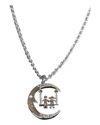 A silver necklace with a crescent moon pendant featuring two figures on a swing, accented with crystals.