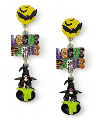 A pair of whimsical earrings with a yellow moon and bat, colorful "Hocus Pocus" lettering, and a witch figure brewing a potion,