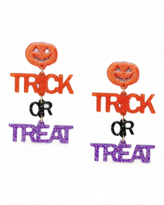 Glittery dangling earrings with a smiling pumpkin above the words 'Trick or Treat' written in bold, sparkly orange and purple letters